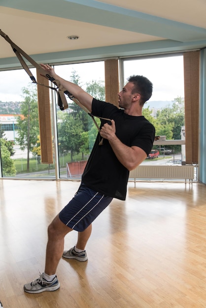 Fitness Trx Cinghie di sospensione Esercizi di allenamento Donne e uomini che lavorano con il proprio peso in palestra