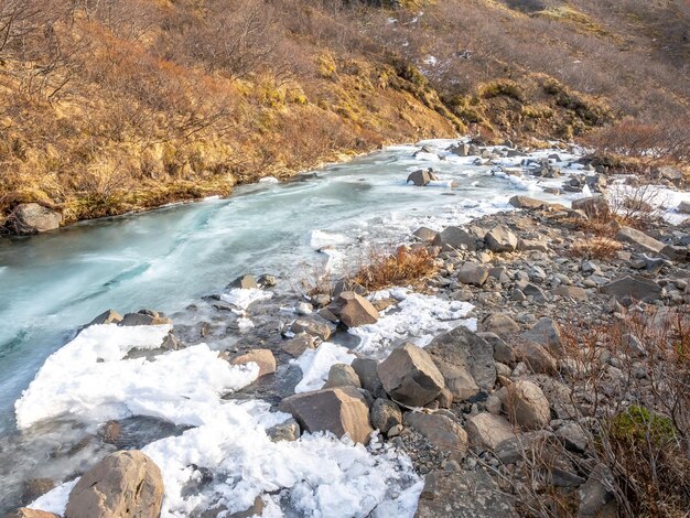 Fiume ghiacciato nel parco nazionale di Skaftafell vicino alla cascata di Svartifoss nella stagione invernale dell'Islanda