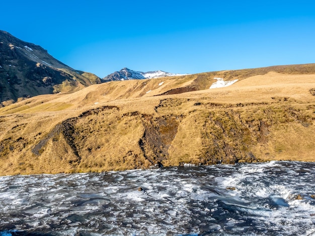 Fiume in streaming in cima alla cascata Skogafoss con neve e ghiaccio nella stagione invernale in Islanda