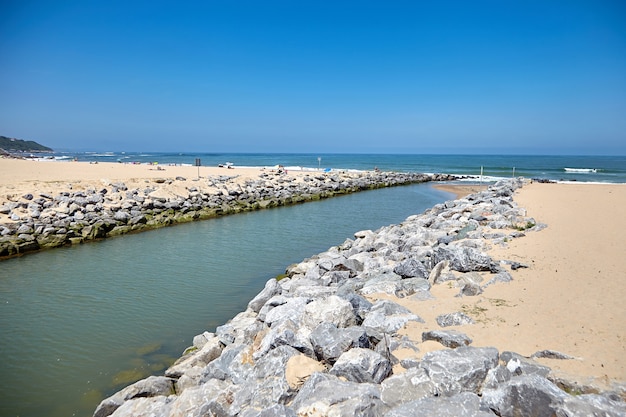 Fiume La Uhabia che scorre nell'oceano con spiaggia di sabbia in una città costiera Bidart, Francia