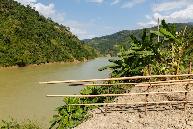 Fiume Nam na, fiume di montagna del Vietnam e recinzione di bambù in primo piano