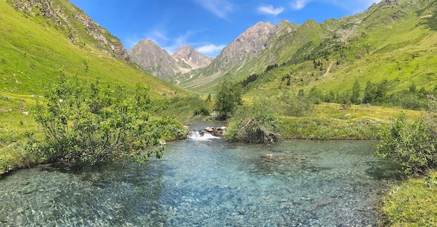 Fiume nella valle alpina con sfondo di montagna di picco