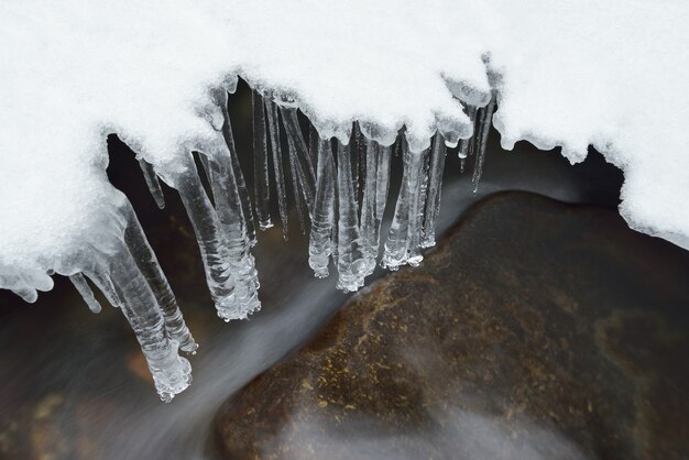 Fiume sotto il ghiaccio e la neve. Bellissimi ghiaccioli