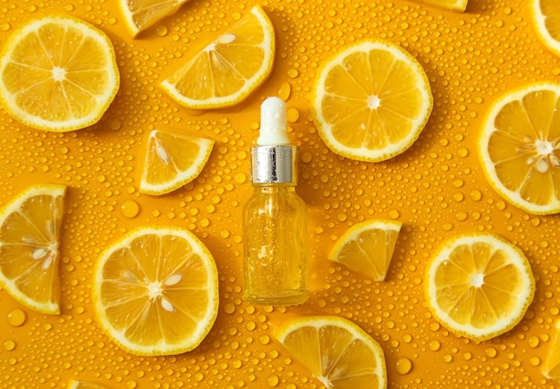 Flacone di cosmetici e gocce di limone liquido idratante Acido ialuronico Messa a fuoco selettiva