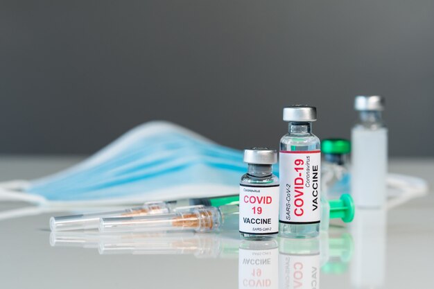 Flaconi di vaccino contro il coronavirus covid-19 e medicina per iniezione di siringhe e maschera medica