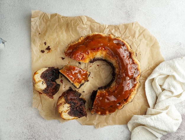 flan al cioccolato, chocoflan messicano, torta biscotto al cioccolato e budino di crema pasticcera al caramello con salsa al caramello in cima, su un tavolo di legno scuro