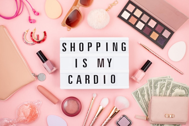 Flat lay con lightbox e citazione divertente Shopping è il mio cardio