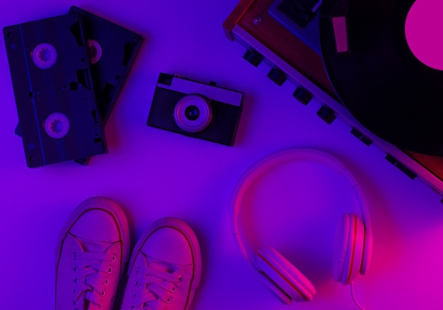 Flat lay retrò anni '80 oggetti della cultura pop lettore in vinile cuffie videocassette sneakers fotocamera pellicola