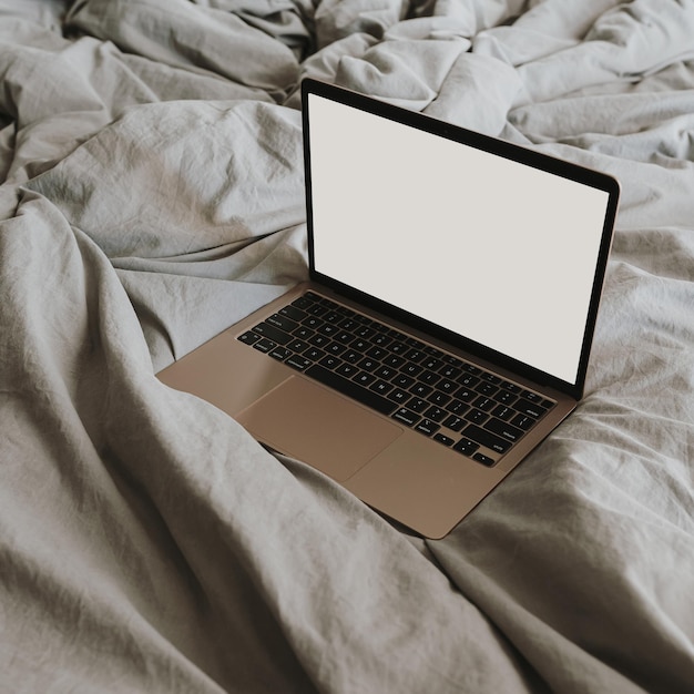 Flatlay di computer portatile con schermo spazio copia vuota Biancheria da letto grigio neutro Concetto di area di lavoro domestica bohémien estetica Lavoro a casa