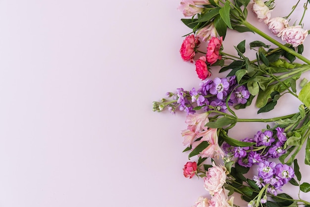 Flatlay di fiori di rose rosse e rosa su sfondo blu Piatto vista dall'alto Composizione floreale minimalista San Valentino Concetto di festa della mamma