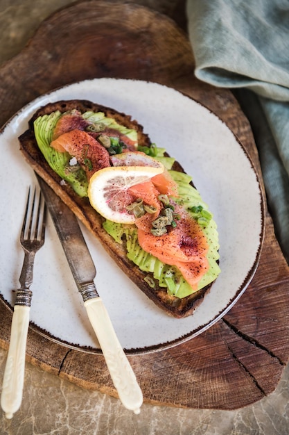 Flatlay di sano toast di avocado con lievito naturale e salmone affumicato