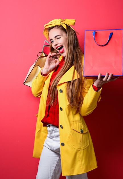 Flirty ragazza in cappotto giallo tenere borse della spesa venerdì nero