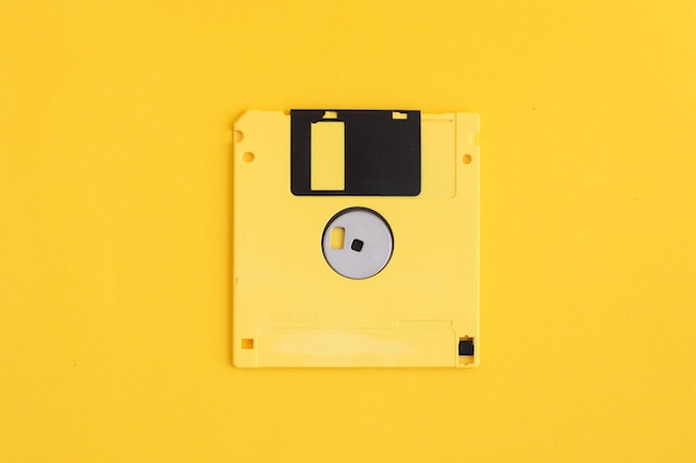 Floppy disk giallo su superficie gialla