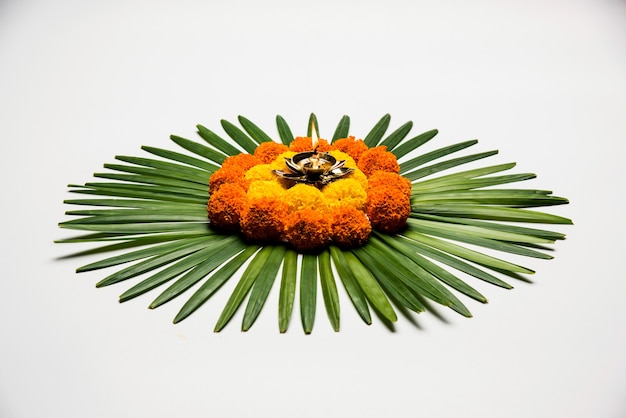 Flower Rangoli per Diwali o Pongal Festival realizzato utilizzando fiori di calendula o Zendu e petali di rosa su sfondo lunatico o bianco, messa a fuoco selettiva
