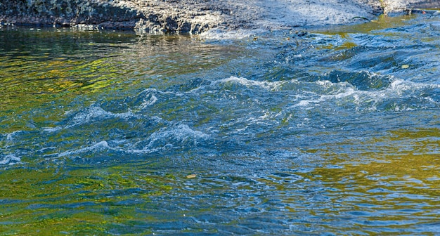 flusso d'acqua e spruzzo da una pietra vicino