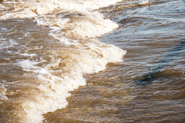 Flusso di acqua di fusione sporca nella soleggiata giornata primaverile.