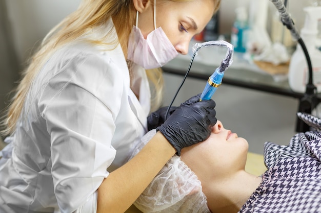 Flusso di lavoro delle sopracciglia con microblading in un salone di bellezza. Donna con le sopracciglia colorate. Trucco semipermanente per sopracciglia. Concentrati sul viso e sulle sopracciglia della modella