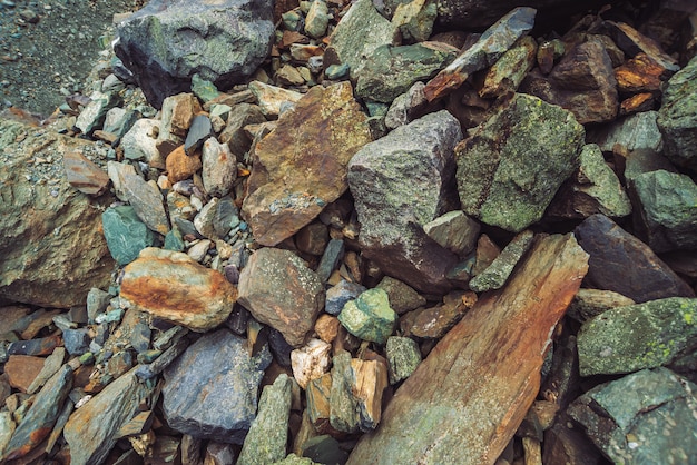 Flusso di massi multicolore. Fine della roccia allentata in su. Pietre casualmente sparse in natura. Incredibile sfondo dettagliato di massi di altopiani con muschi e licheni. Texture naturale del terreno montano.