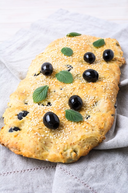 Focaccia di pane italiano con olive, aglio e menta, verticale