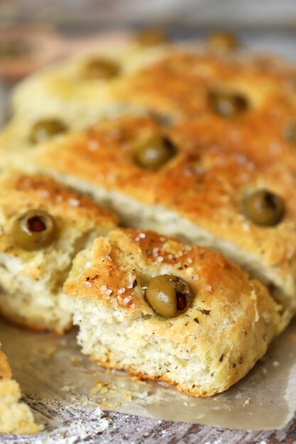 Focaccia fresca fatta in casa con erbe italiane. Cucinare a casa. Pane tradizionale italiano con olive.