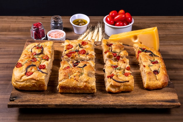 Focaccia italiana tradizionale con pomodorini, olive nere e rosmarino