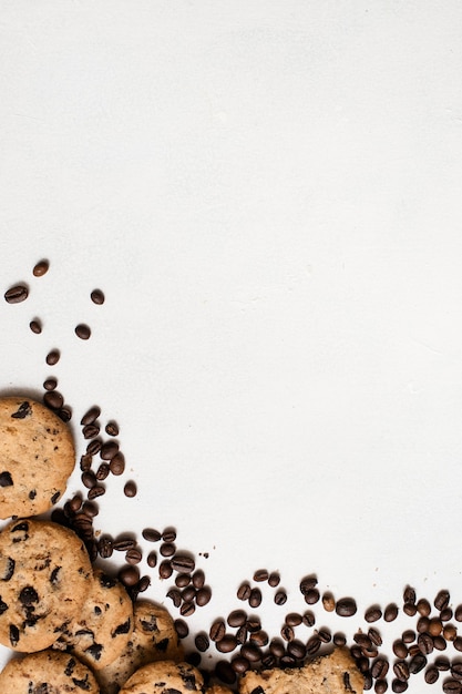 Focaccina integrale al cioccolato con chicchi di caffè su sfondo bianco, vista dall'alto con spazio libero. Biscotti deliziosi e arte culinaria del concetto di caffè