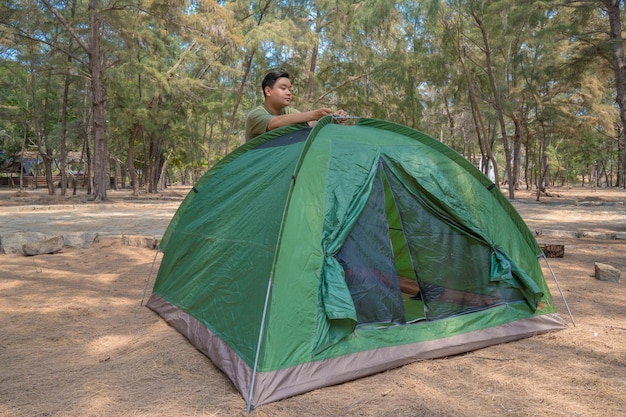 Focus boy scout mette una tenda nella foresta Campo nella tenda turista che imposta una tenda sul campeggio