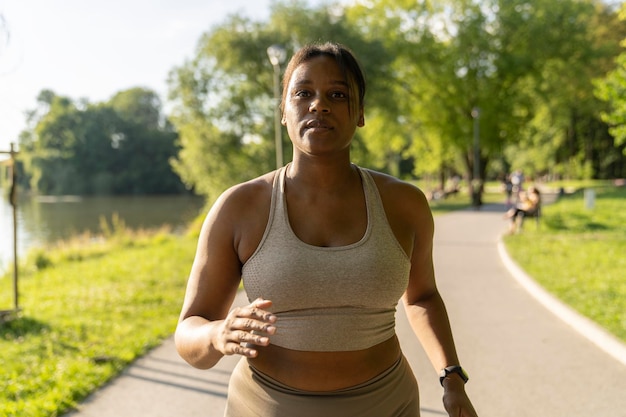Focus donna afroamericana che corre nel parco