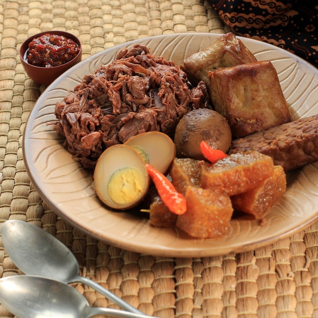 Focus selezionato Gudeg. Un piatto iconico e leggendario di Yogyakarta in Indonesia. Stufato di Jack Fruit accompagnato con stufato piccante di cracker di pelle di bovino e uova marroni, tofu, tempeh e Sambal.