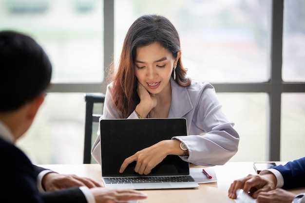 Focus selezionato sulle donne d'affari che discutono e si concentrano sulla presentazione di laptop alla riunione.