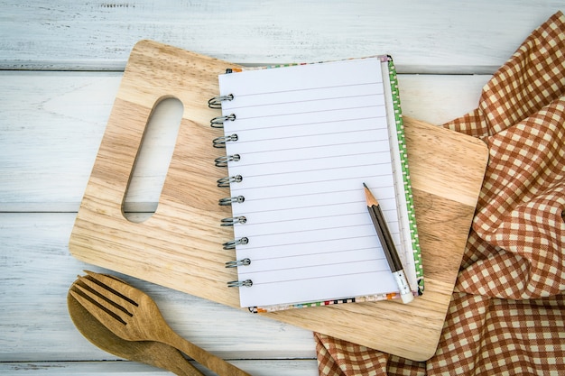 foderato libro carta blocco note sul tagliere tagliere e tovaglia con forchetta in legno e sp