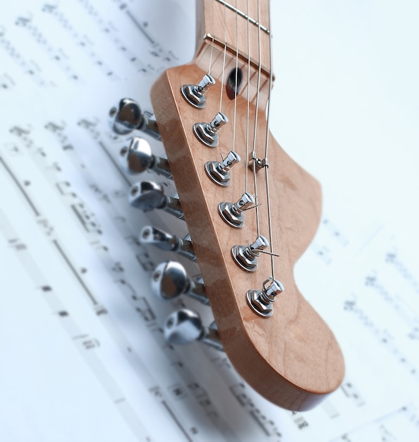 fogli di musica e chitarra elettrica in bianco e nero