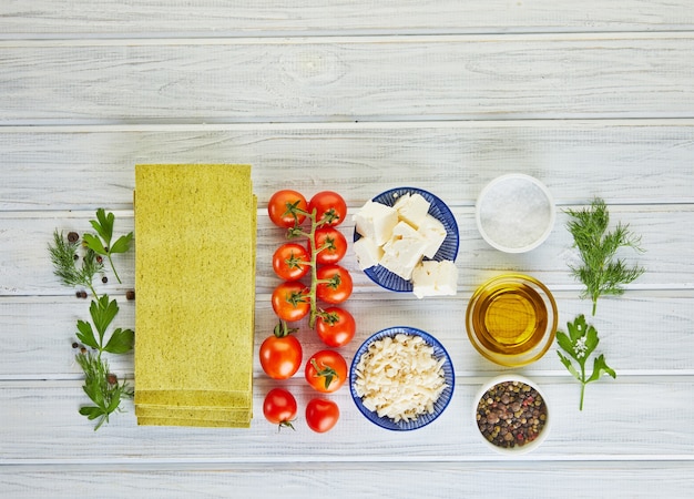 Fogli per lasagne con spinaci e ingredienti pomodorini, formaggio