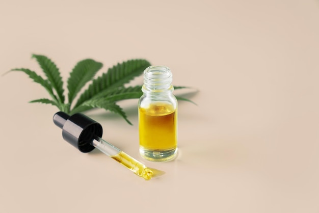 Foglia di canapa sativa di cannabis legalizzata e contenitore di olio di CBD con coperchio contagocce