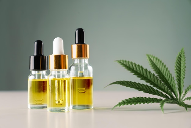 Foglia di canapa sativa di cannabis legalizzata e contenitore di olio di CBD con coperchio contagocce