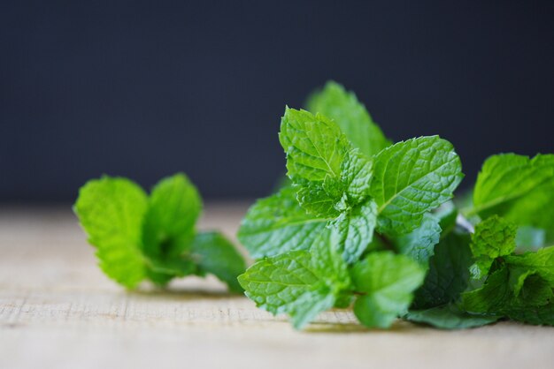 Foglia di menta piperita su legno - foglie di menta fresca su sfondo scuro