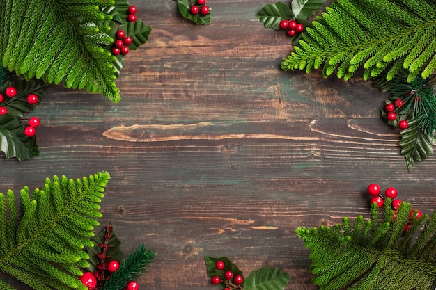 Foglia di pino di Natale e vischio sul tavolo di legno, rosso