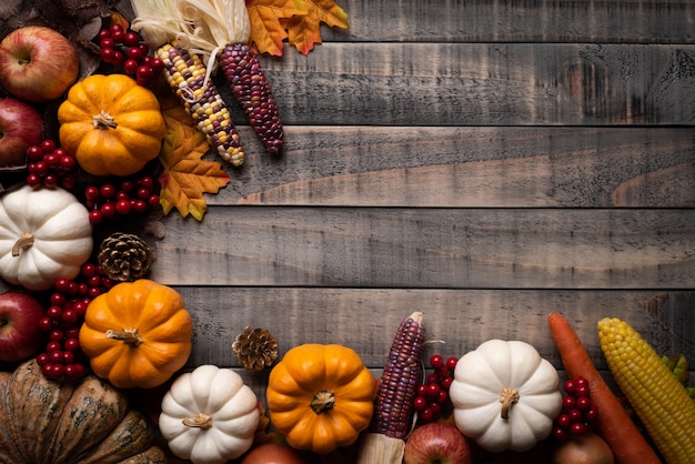 Foglie di acero autunno con zucca, mais e bacche rosse