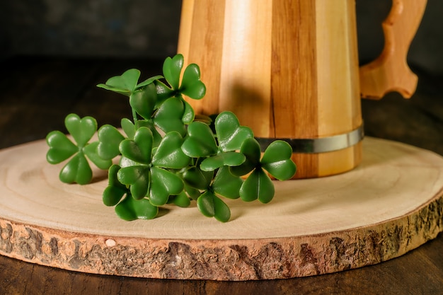 foglie di acetosella e boccale di legno di birra verde.