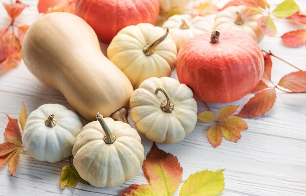 Foglie di autunno e zucche sopra il vecchio fondo di legno