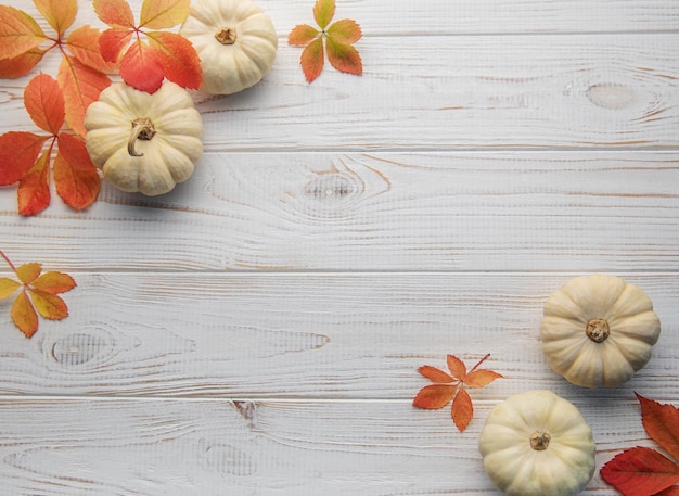 Foglie di autunno e zucche sopra il vecchio fondo di legno