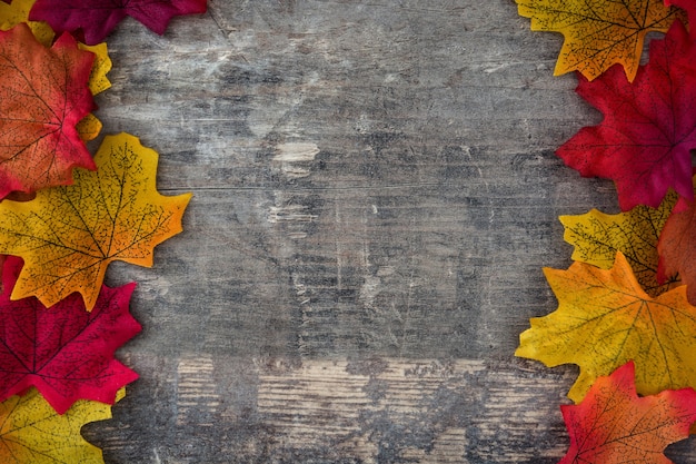 Foglie di autunno sul fondo della struttura di legno