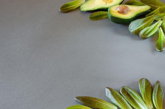 Foglie di avocado e spinaci a fette su sfondo grigio