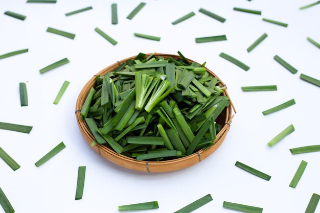 Foglie di erba cipollina cinese fresca su sfondo bianco.