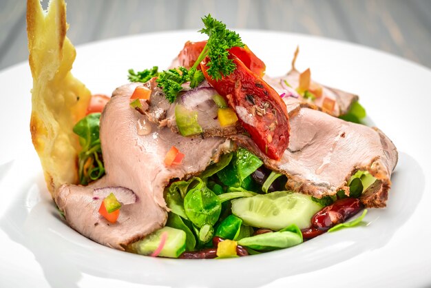 Foglie di insalata con arrosto di manzo e pomodori ciliegia essiccati al sole