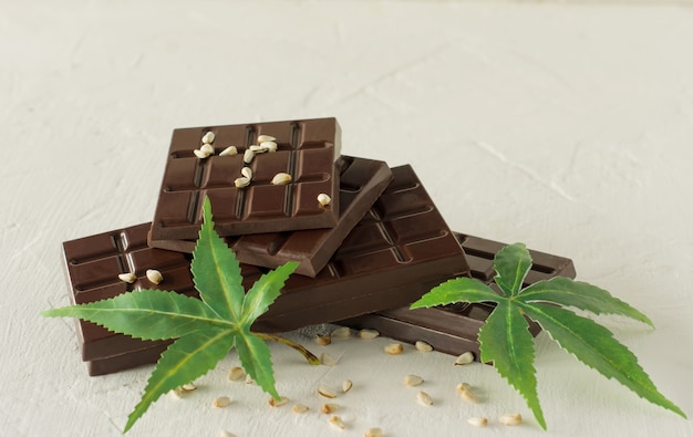 Foglie di marijuana e cioccolato fondente su bianco