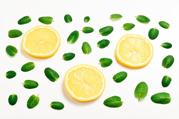 Foglie di menta sono fette di limone su sfondo bianco