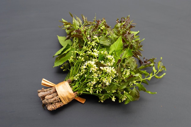 Foglie di neem e fiori sul tavolo scuro.