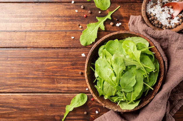 Foglie di rucola fresca nella vista dall'alto della ciotola marrone