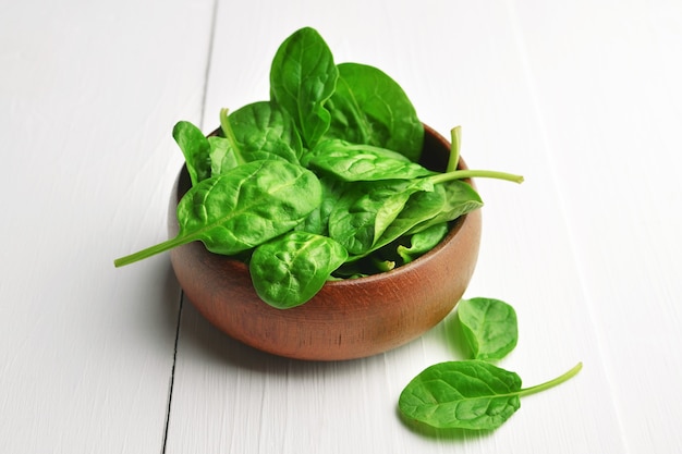 Foglie di spinaci freschi in ciotola di legno